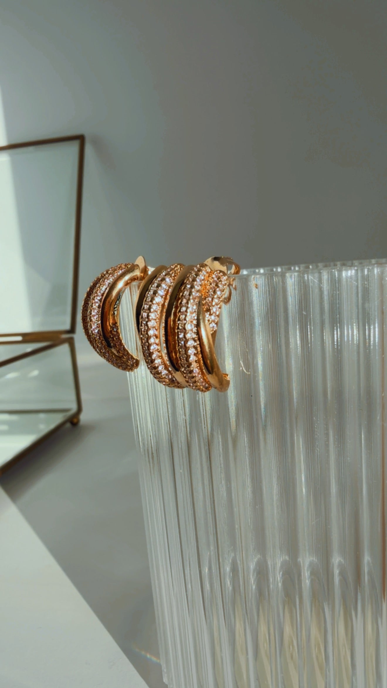 Brinco argola entrelaçado cravejado